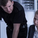 man and woman beside computer working at a police station