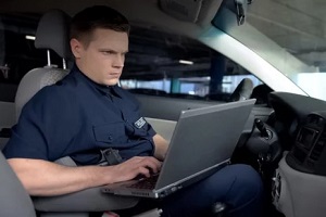 young police officer working on laptop