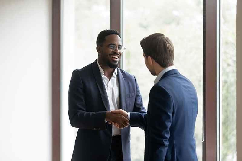 an interviewer shaking hands with a job applicant