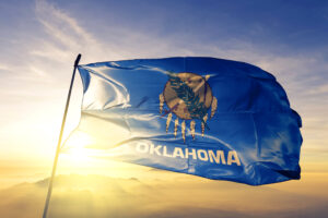 Oklahoma flag flying in front of the sunrise