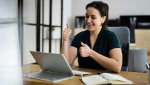 Woman giving computer thumbs up