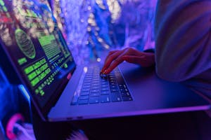 Person Using Laptop with Green Symbols on Screen