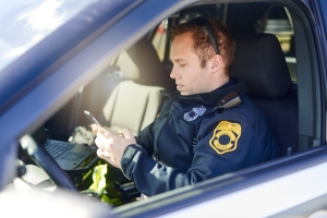Police, phone and patrol with man in car for crime investigation unit, forensic and law enforcement. Justice, security guard and detective with person for safety officer, emergency and surveillance